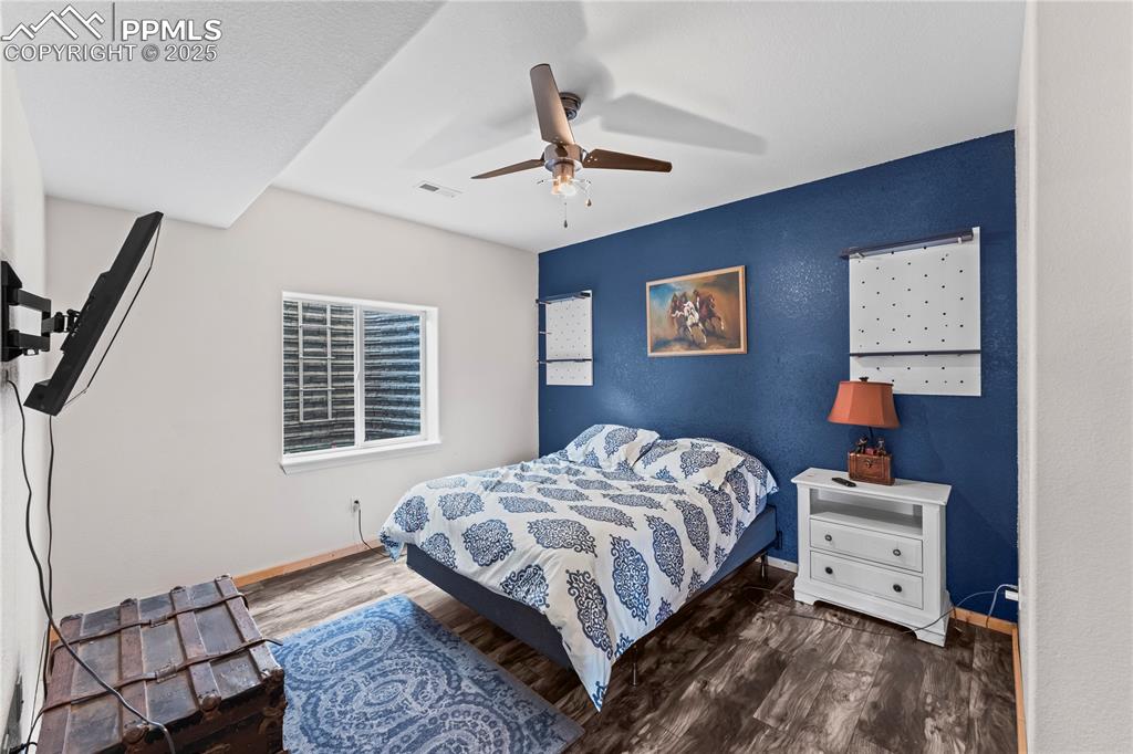 Image 41 of 48: Basement Bedroom with dark wood finished floors and ceiling fan