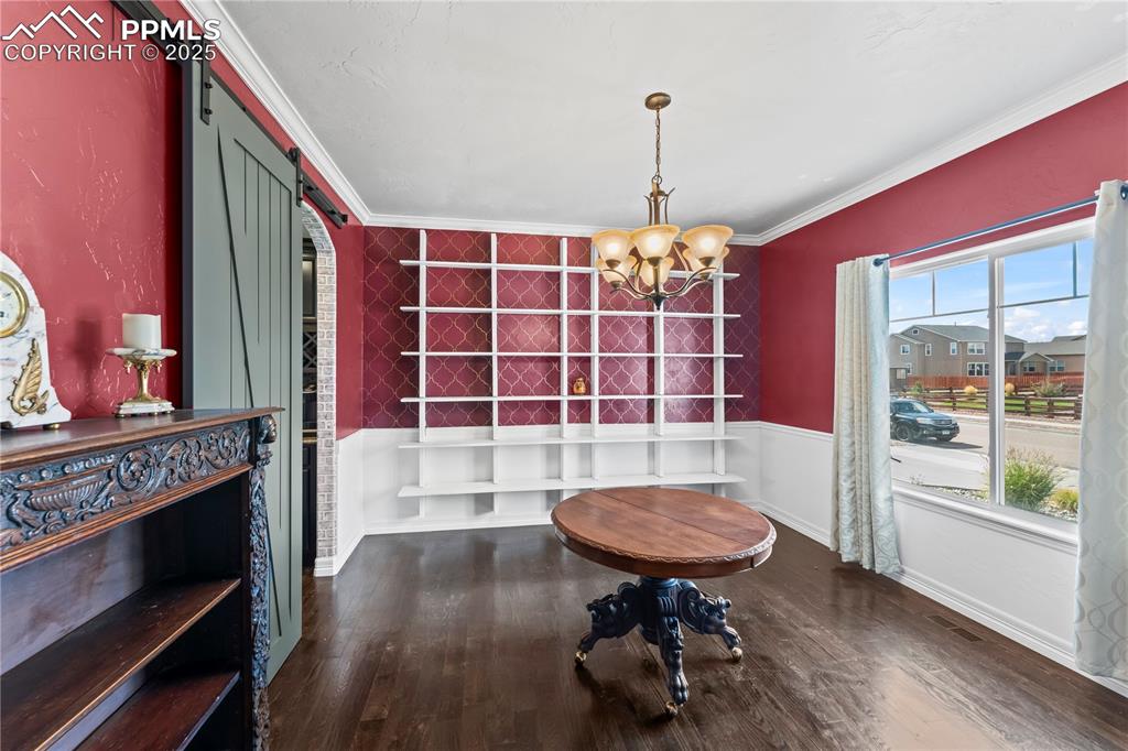 Image 7 of 48: Main level formal dining area featuring a barn door, dark wood finished flo
