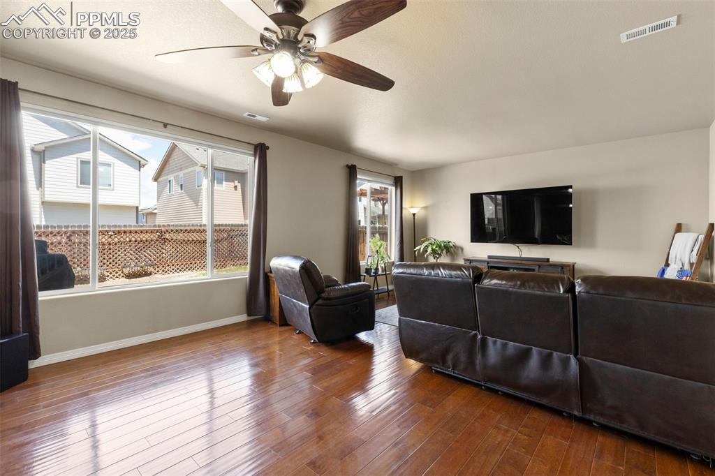 Image 14 of 27: Living area featuring wood finished floors and ceiling fan