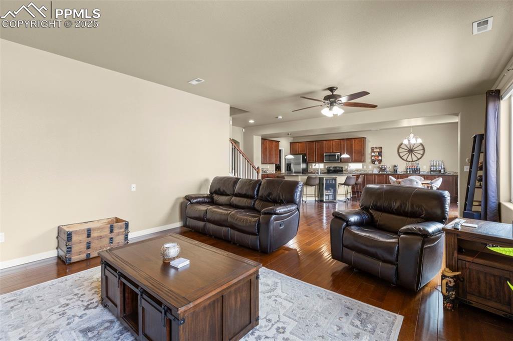 Image 15 of 27: Living room featuring a ceiling fan, dark wood finished floors, and recesse