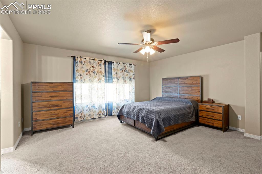 Image 16 of 27: Carpeted bedroom with baseboards and ceiling fan