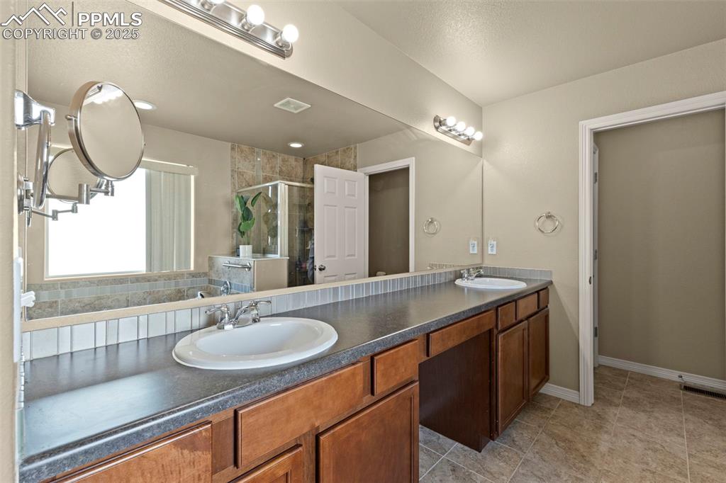 Image 18 of 27: Full bath with a stall shower and double vanity