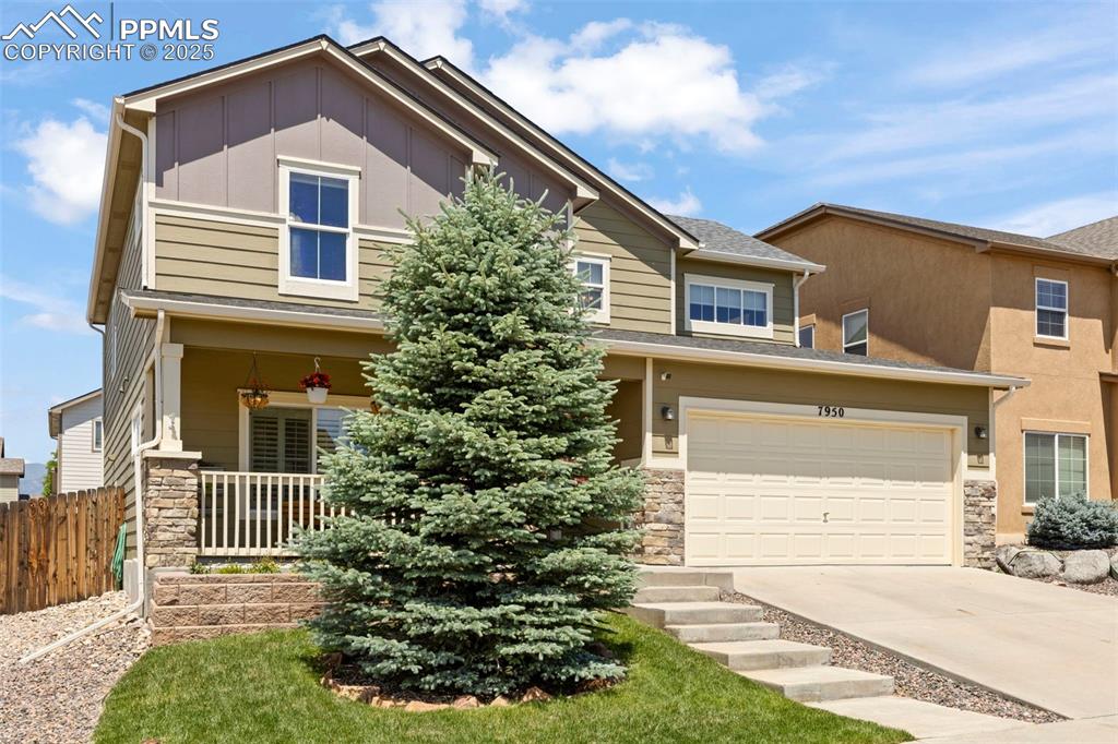 Image 2 of 27: Craftsman house with stone siding, driveway, covered porch, and board and b