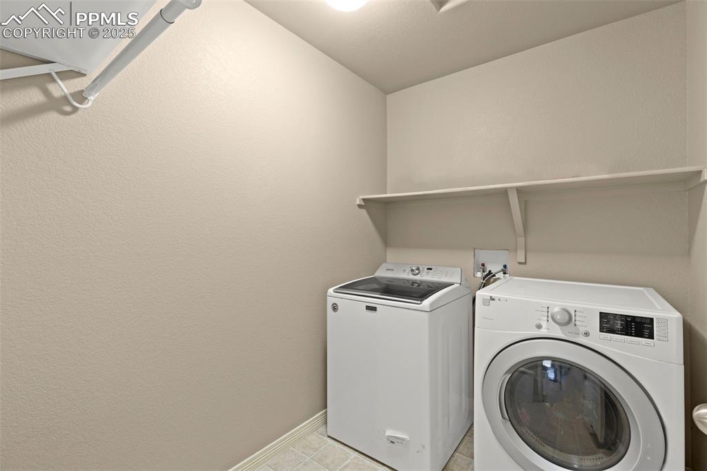 Image 25 of 27: Laundry area featuring washer and clothes dryer and baseboards