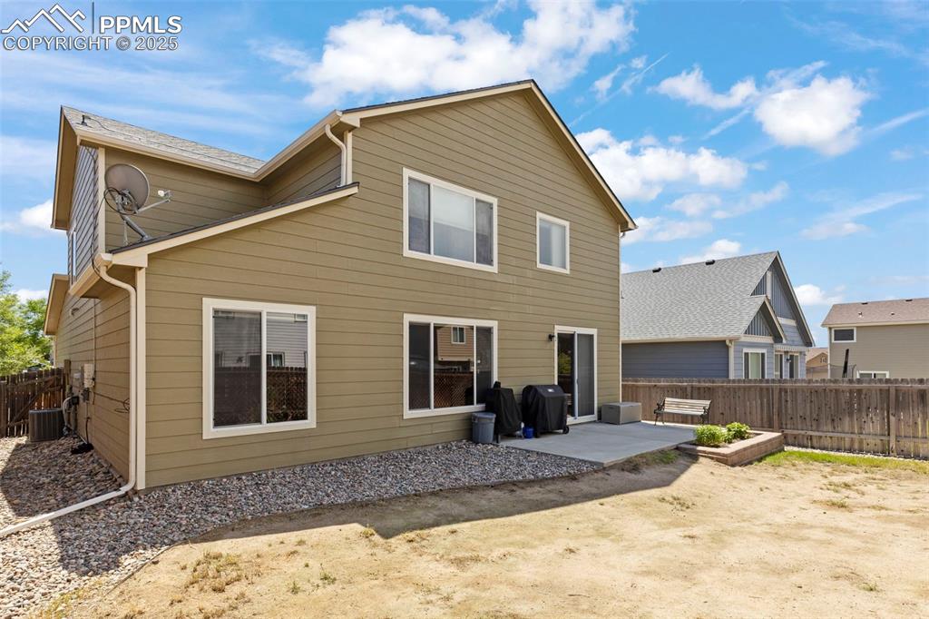 Image 4 of 27: Rear view of property featuring a patio area and a fenced backyard