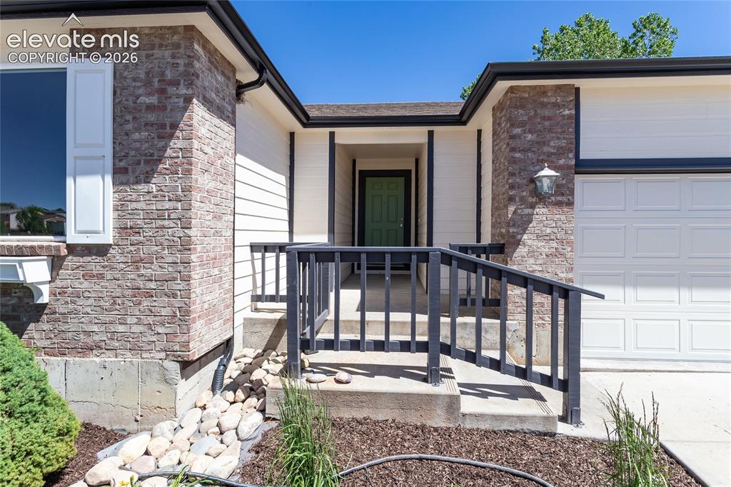Image 6 of 39: Low maintenance plants, river rock & entry railing!