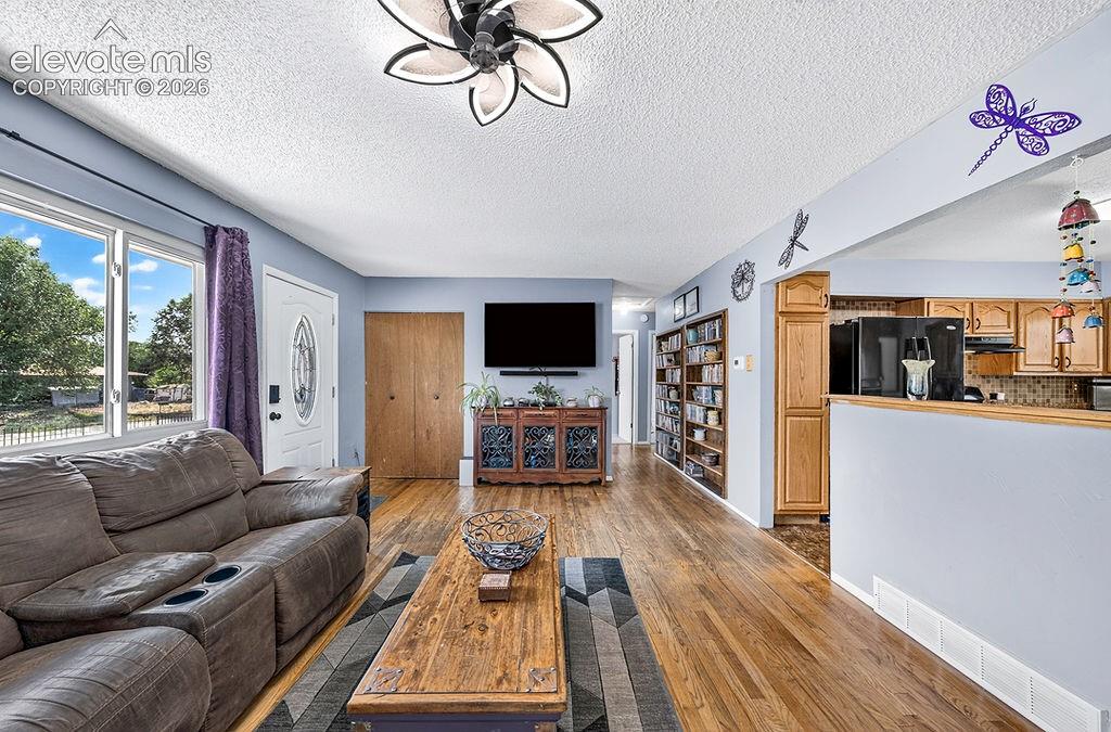 Image 17 of 44: Open concept living area featuring wood-finish flooring, a decorative ceili