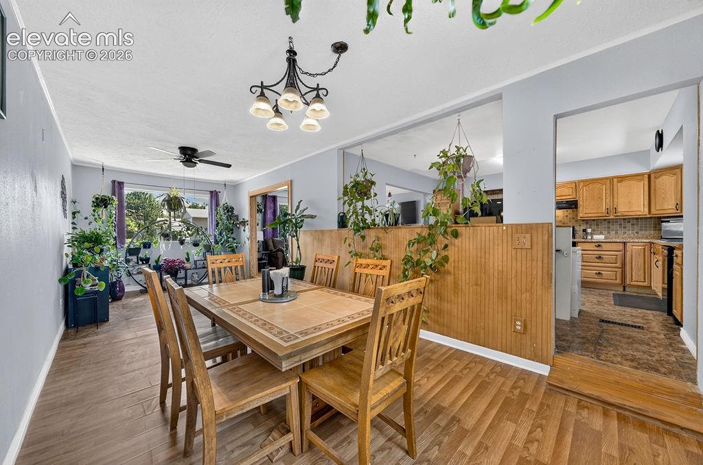Image 19 of 44: Dining area with wood-finish flooring, a decorative chandelier, and a large