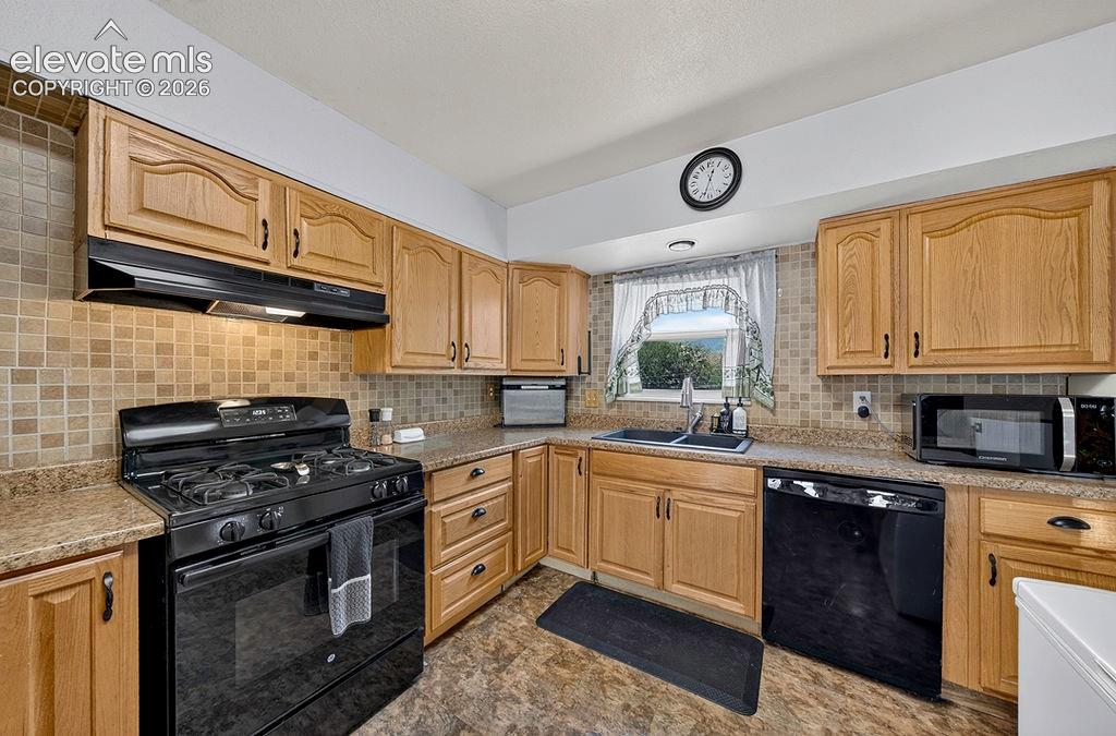 Image 23 of 44: Kitchen featuring light-finish cabinetry, a full suite of black appliances,