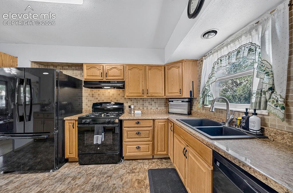 Image 24 of 44: Kitchen featuring light wood cabinetry, a dual basin sink with a gooseneck 