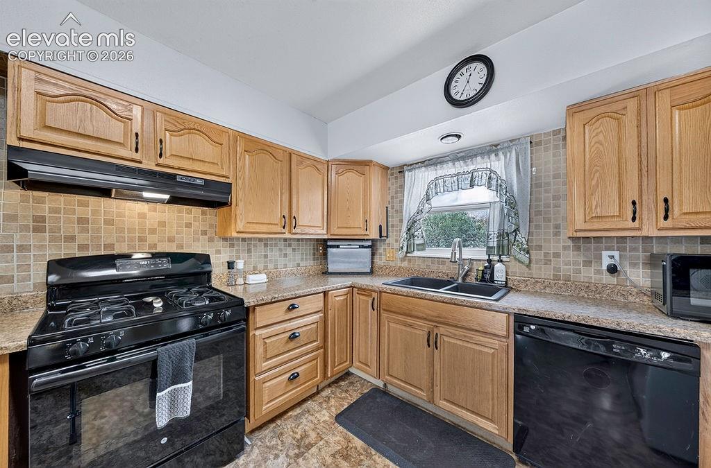 Image 25 of 44: Kitchen featuring wood-finish cabinetry, a black gas range, black dishwashe