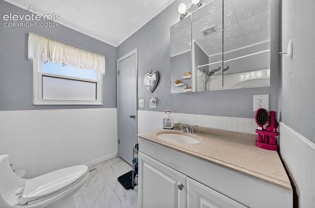 Image 29 of 44: Bathroom featuring a white vanity with an integrated sink, a light-toned co
