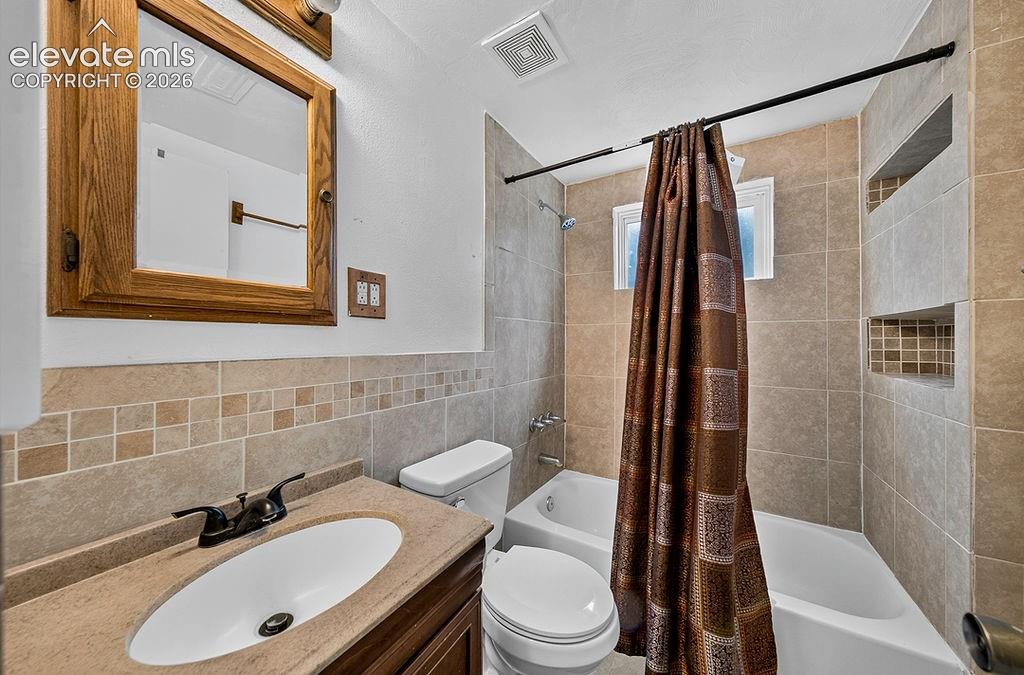 Image 35 of 44: Bathroom featuring a wood-framed mirror, vanity with an integrated sink, an