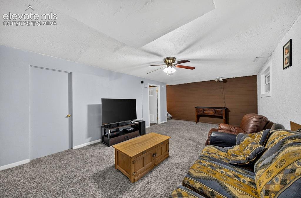 Image 36 of 44: Spacious room featuring light gray walls, textured white ceiling, and plush