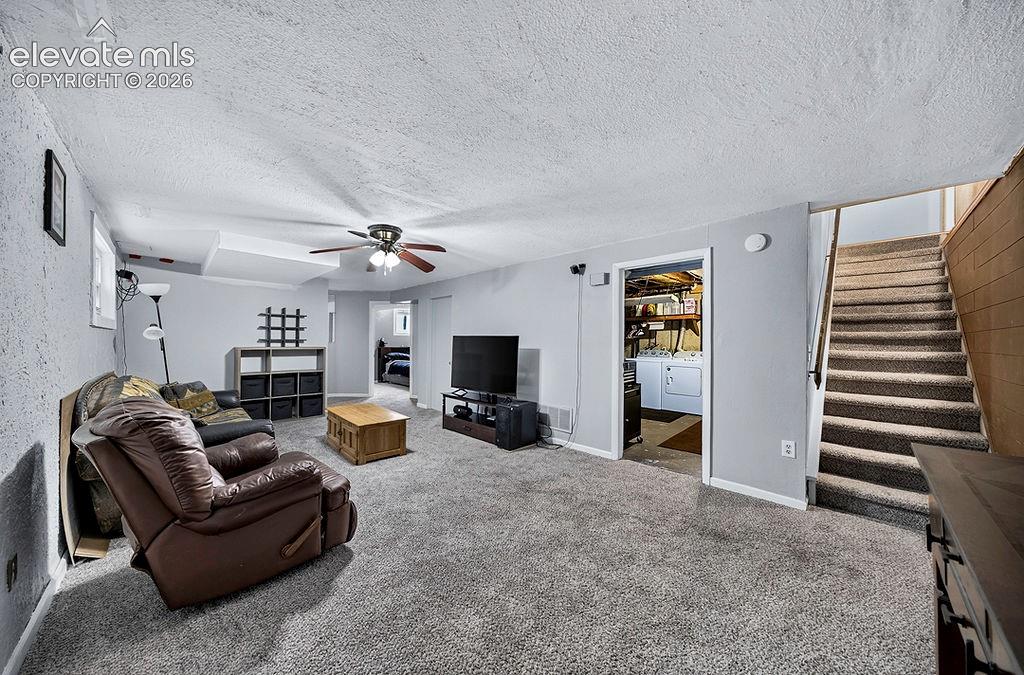 Image 37 of 44: Carpeted living area featuring light gray walls, a ceiling fan with integra