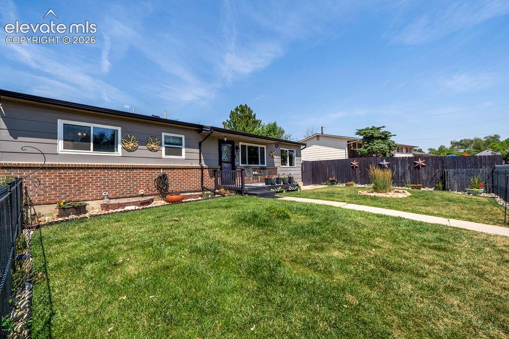 Image 4 of 44: Single-story residence featuring grey siding and brick accents