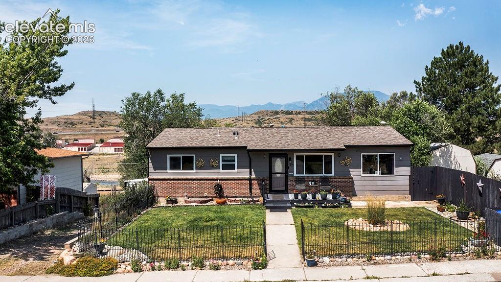Image 42 of 44: Ranch-style exterior with gray siding and brick accents