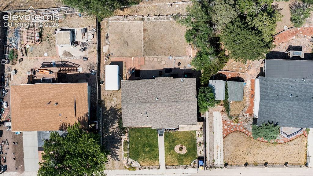 Image 7 of 44: Aerial perspective showcasing the property with a shingle roof and a green 