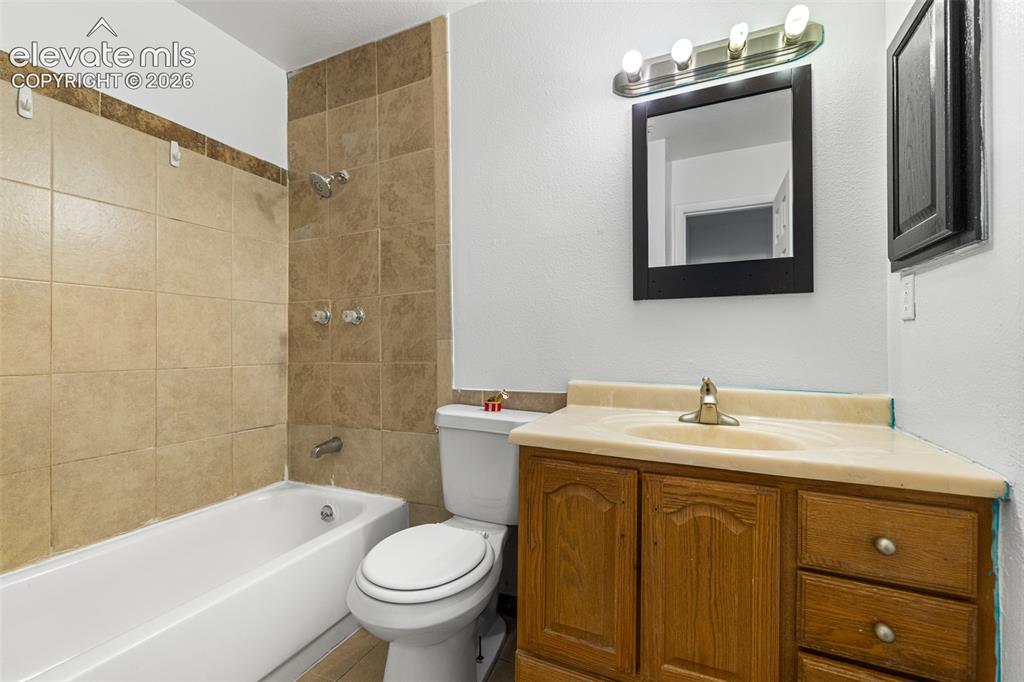 Image 16 of 19: Bathroom featuring a wood-finish vanity with dual drawers and cabinet stora