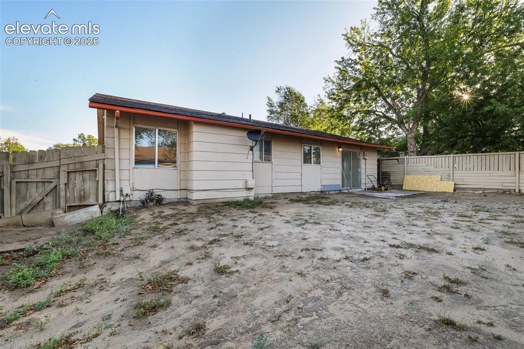 Image 19 of 19: Rear exterior featuring horizontal siding, a sliding glass door, and a part