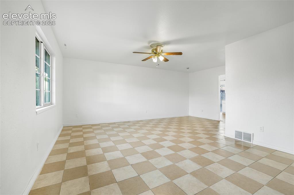 Image 3 of 19: Spacious room featuring alternating tan and cream checkered tile flooring, 