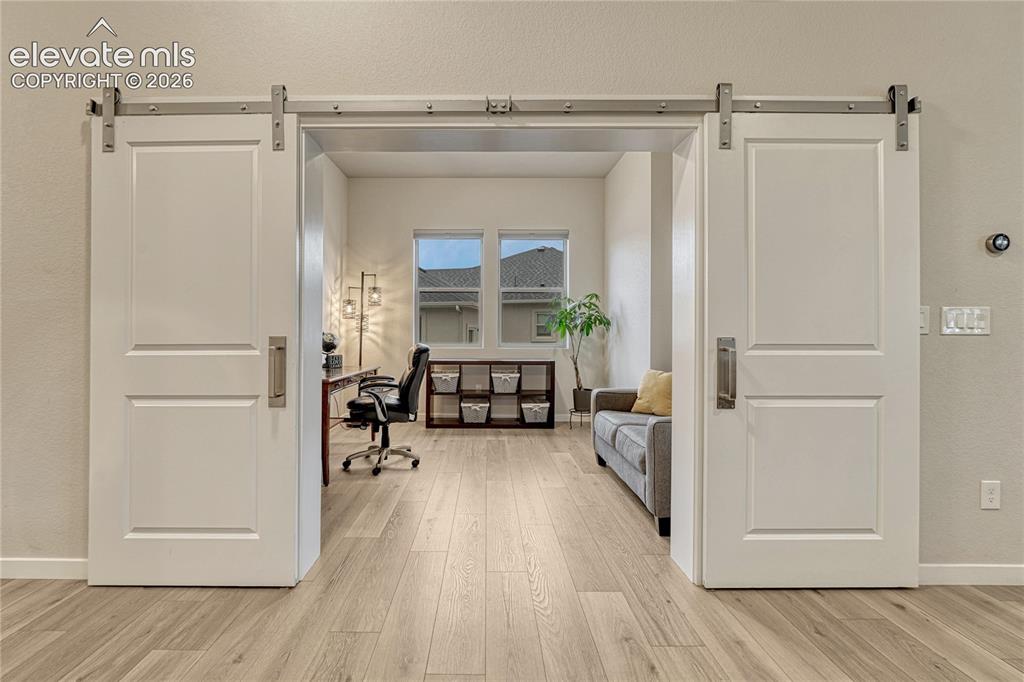 Image 16 of 41: Two barn doors make a statement entrance to the main level office. 
