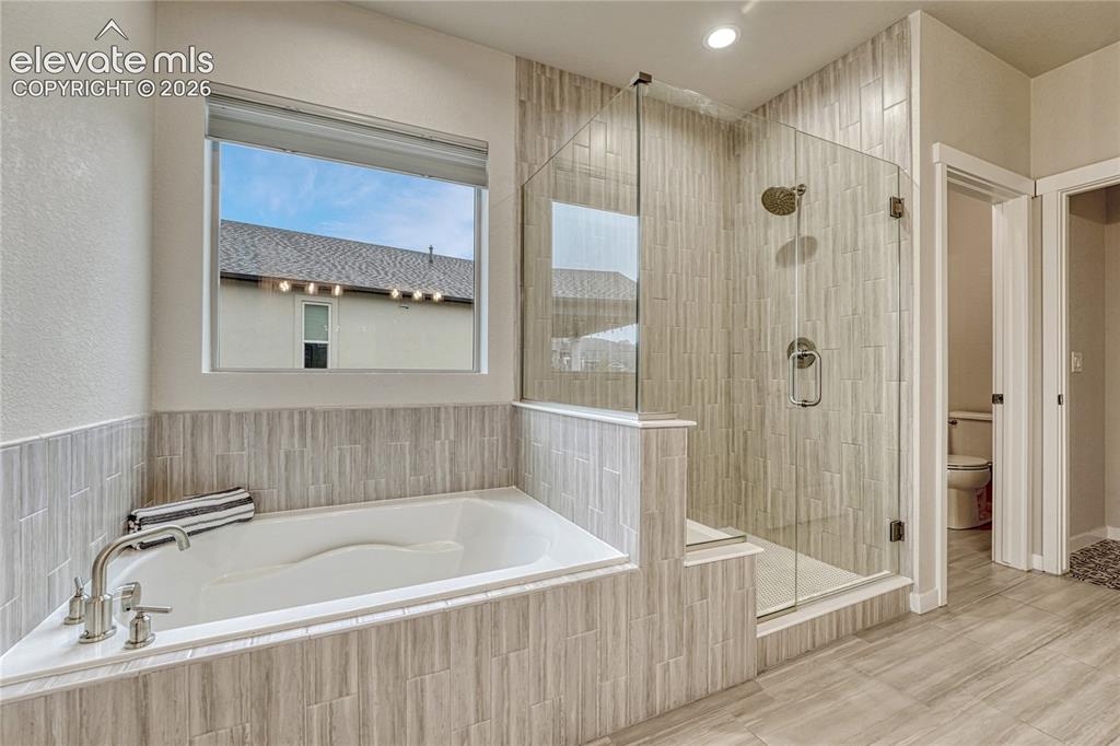 Image 21 of 41: 5-piece primary bathroom with soaker tub, walk-in closet...