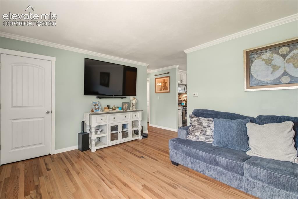 Image 3 of 31: Inviting Wood Floors and Crown Molding