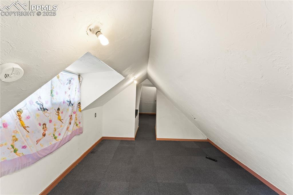 Image 18 of 36: Additional living space featuring baseboards, carpet flooring, and vaulted 