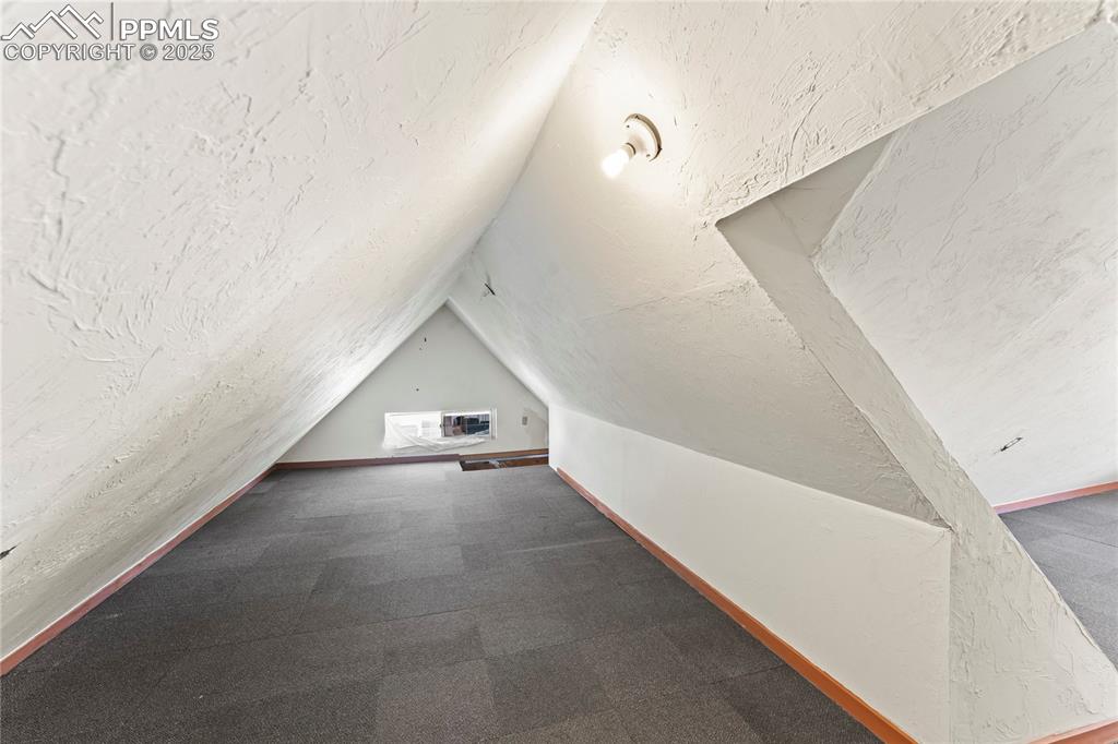 Image 21 of 36: Additional living space featuring carpet floors and vaulted ceiling