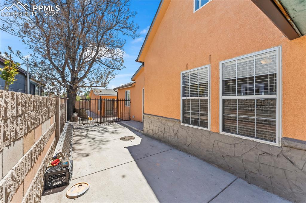Image 28 of 36: View of side of home featuring a fenced backyard, stucco siding, and a pati