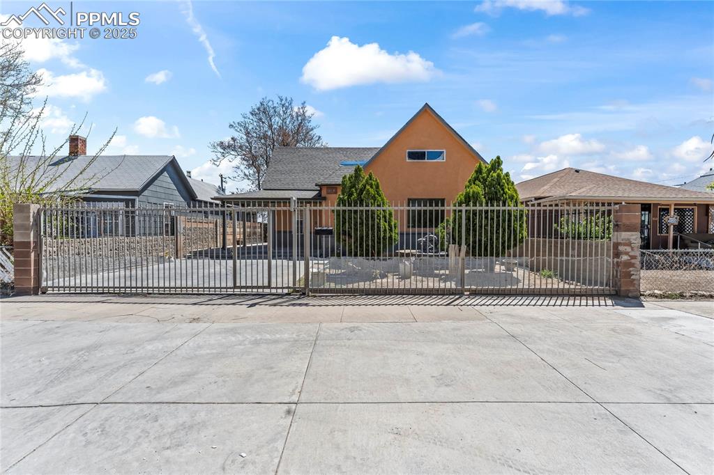 Image 3 of 36: View of front of house featuring a gate, a fenced front yard, and stucco si