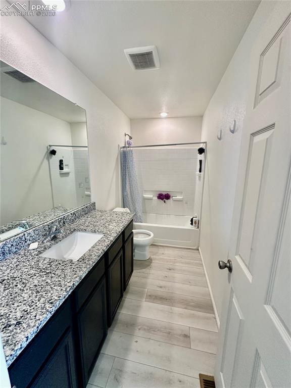 Image 15 of 17: Bathroom with shower / tub combo, vanity, and light wood-type flooring
