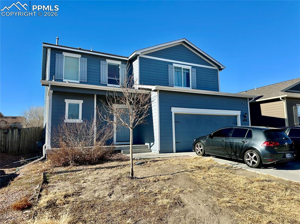 Image 2 of 17: Traditional home with driveway, a porch, and an attached garage