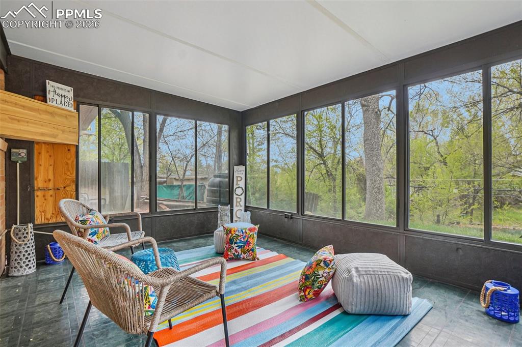 Image 18 of 38: This cozy sunroom is full of light and warmth! 