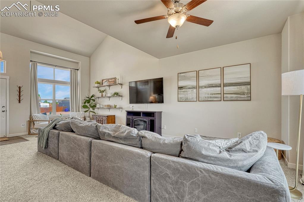 Image 13 of 50: Back inside, large living room with ceiling fan