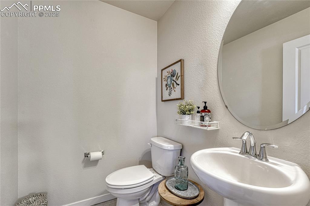 Image 22 of 50: Large main level half bath with pedestal sink