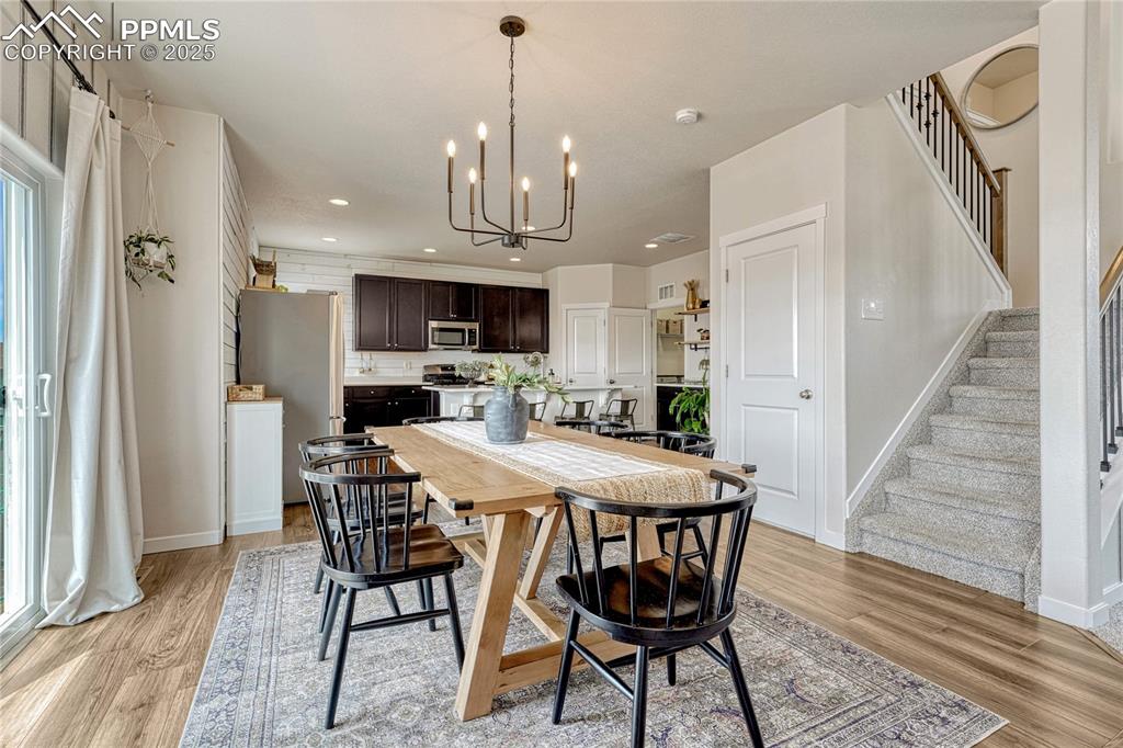 Image 7 of 50: View of dining area with updated light fixture and LVP flooring