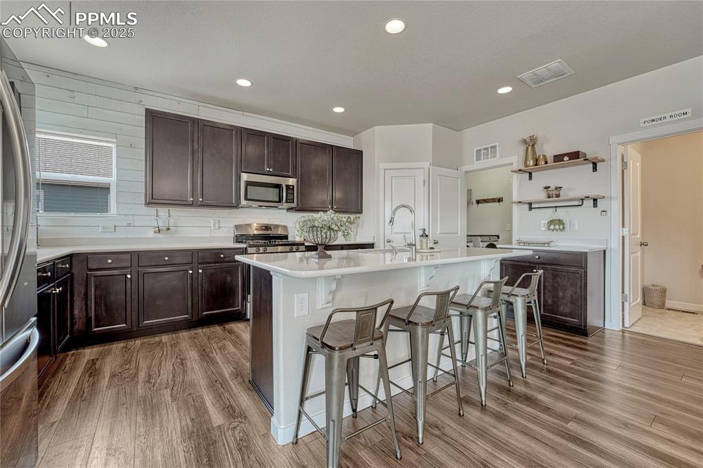 Image 8 of 50: Spacious kitchen with LVP flooring, breakfast bar and quartz counters