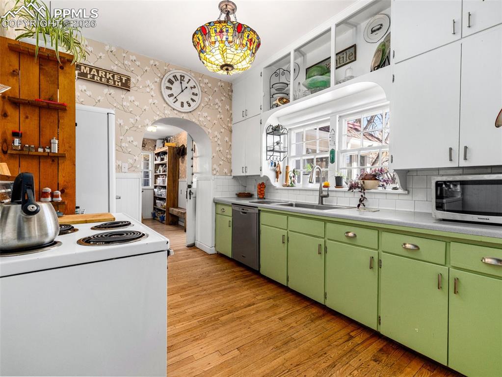 Image 12 of 50: This galley style kitchen with dishwasher, electric range and vintage refri