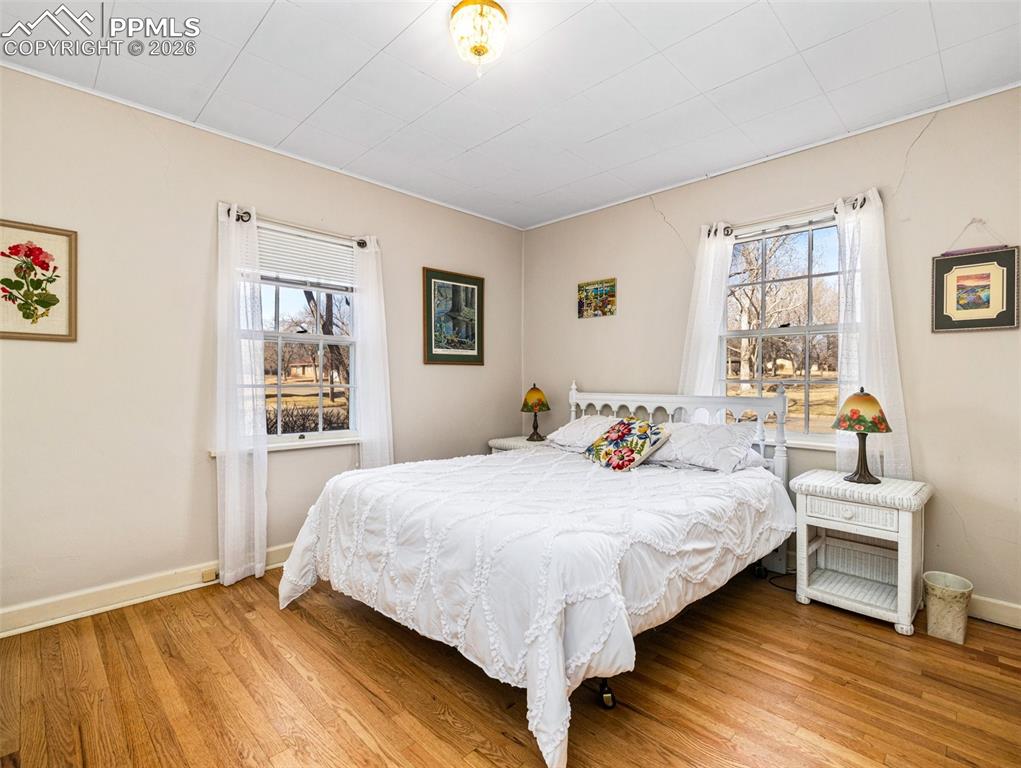 Image 21 of 50: The main level bedroom has newly finished hardwood floors