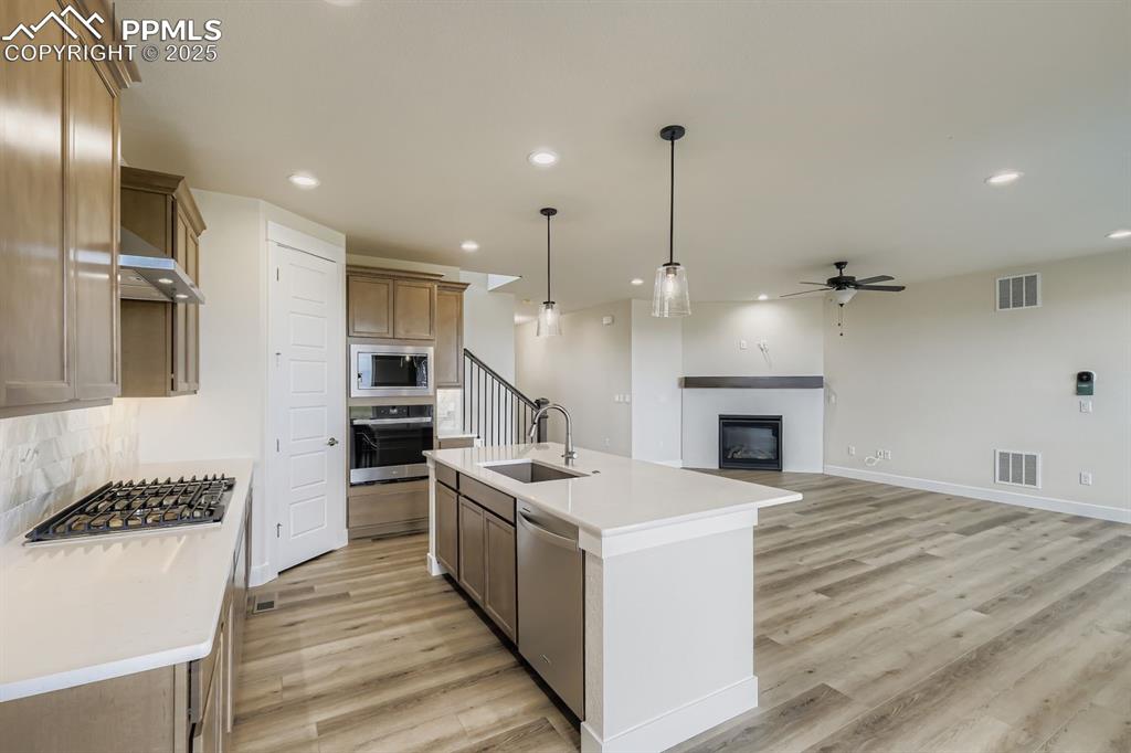 Image 10 of 28: Kitchen with decorative light fixtures, a glass covered fireplace, ceiling 