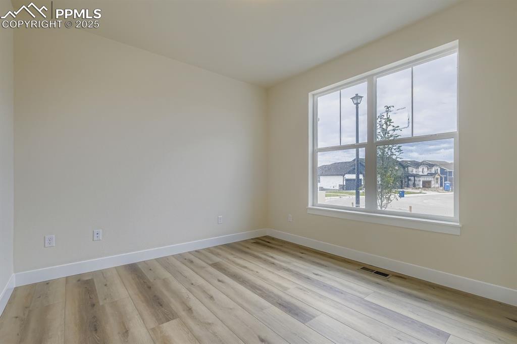Image 7 of 28: Spare room with light wood finished floors and a residential view