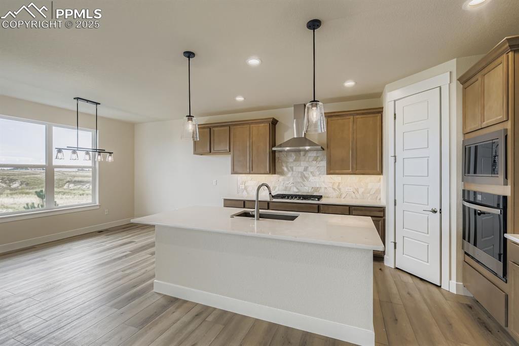 Image 9 of 28: Kitchen featuring pendant lighting, decorative backsplash, a kitchen island