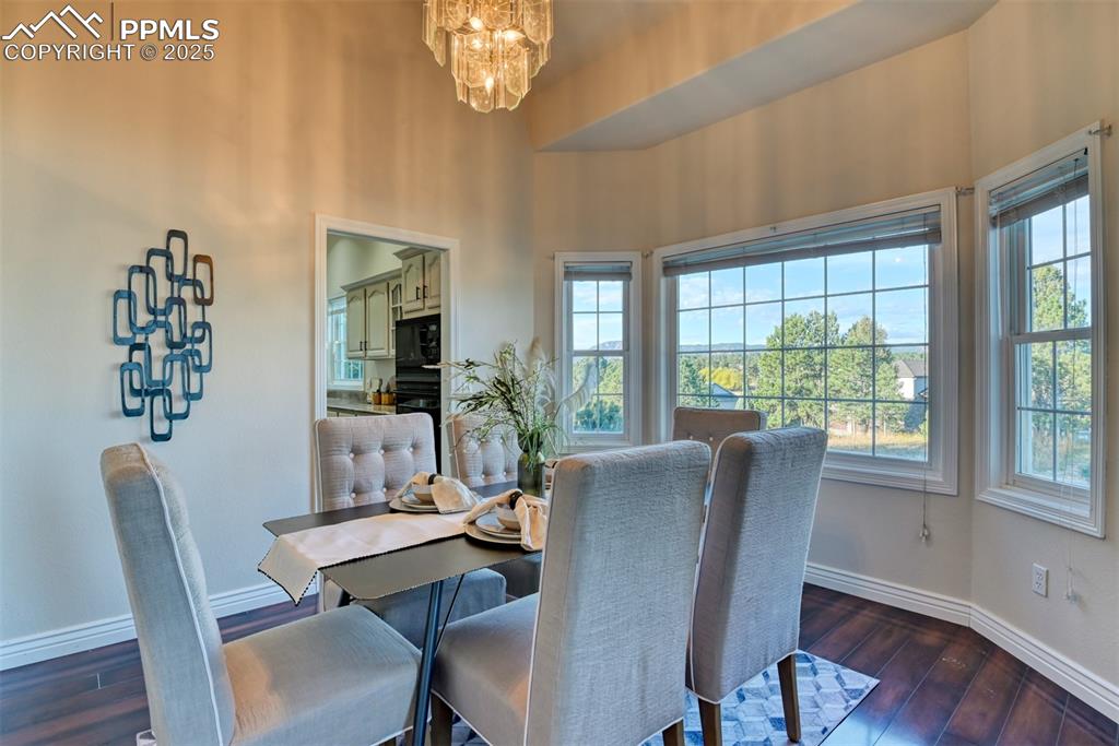 Image 12 of 44: Dining room featuring a chandelier and dark wood-type flooring