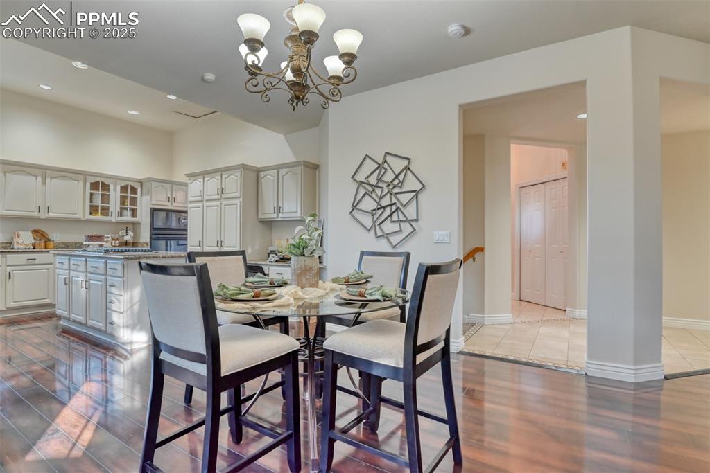 Image 13 of 44: Dining space featuring recessed lighting, dark wood-style floors, and a cha