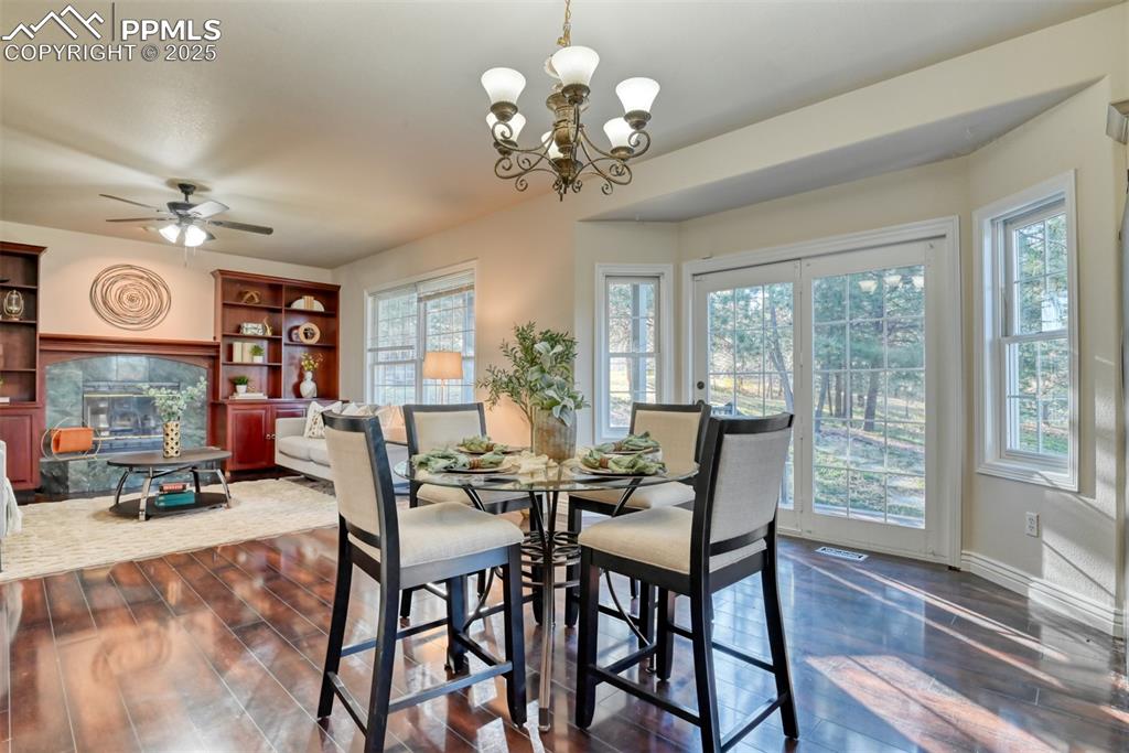 Image 15 of 44: Dining room with dark wood finished floors, a fireplace, healthy amount of 