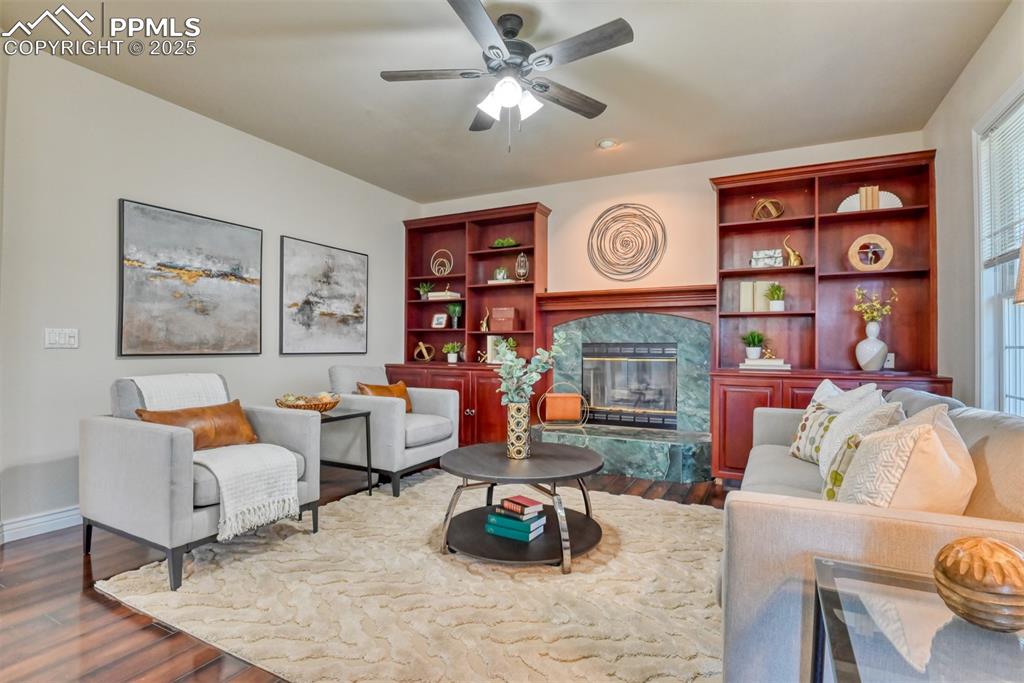 Image 19 of 44: Living room featuring a fireplace, dark wood-style floors, a ceiling fan, a