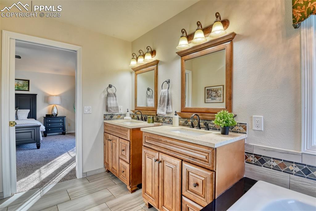Image 32 of 44: Bathroom featuring two vanities and ensuite bathroom