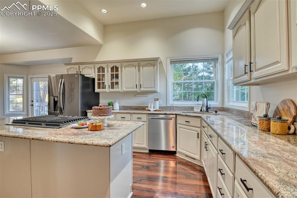 Image 4 of 44: Kitchen featuring appliances with stainless steel finishes, glass insert ca